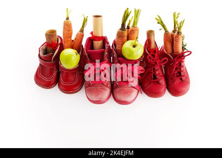 St. Nikolaus - Sinterklaas Tag mit Schuh, Karotte und Äpfeln auf weißem Hintergrund Stockfoto