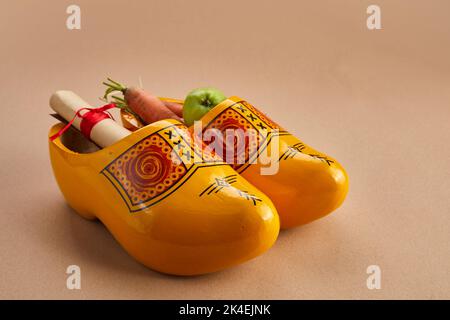 St. Nikolaus - Sinterklaas Tag mit Schuh, Karotte und Äpfel auf Karamell Hintergrund Stockfoto