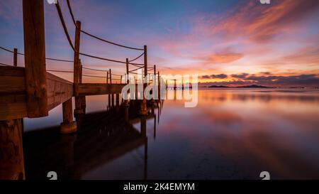 Hölzerner Steg am Strand von Carmol bei Sonnenaufgang, in Cartagena, Region Murcia, Spanien Stockfoto