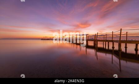 Hölzerner Steg am Strand von Carmol bei Sonnenaufgang, in Cartagena, Region Murcia, Spanien Stockfoto
