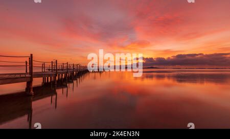 Hölzerner Steg am Strand von Carmol bei Sonnenaufgang, in Cartagena, Region Murcia, Spanien Stockfoto