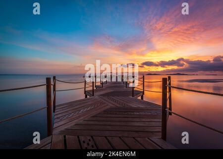 Hölzerner Steg am Strand von Carmol bei Sonnenaufgang, in Cartagena, Region Murcia, Spanien Stockfoto