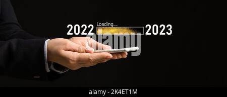 Geschäftsfrau mit Mobiltelefon auf schwarzem Hintergrund. Konzept des neuen Jahres 2022 Stockfoto