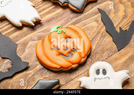 Halloween-Kekse mit Papierfledermäusen auf Holzhintergrund, Nahaufnahme Stockfoto