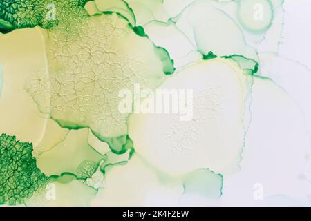 Makro-Nahaufnahme von grünen Farbschichten und abstrakten Formen auf Weiß. Flüssige Tinte, farbenfroher, strukturierter Hintergrund im Vollformat. Lebendige Farben. Stockfoto