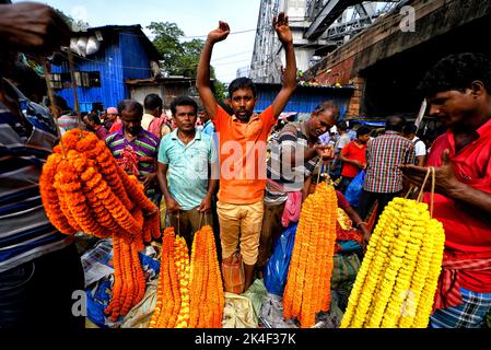 Kalkutta, Indien. 02. Oktober 2022. Händler mit Blumen warten auf Käufer auf dem Blumenmarkt. Der Handel auf Kolkatas Hauptblumenmarkt boomt während des Durga Puja, dem wichtigsten Hindu-Fest Westbengals. Das Festival findet vom 1. Bis 5. Oktober statt. Kredit: SOPA Images Limited/Alamy Live Nachrichten Stockfoto