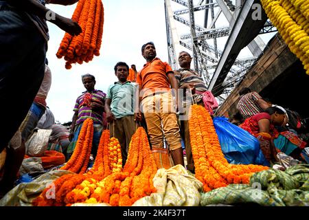 Kalkutta, Indien. 02. Oktober 2022. Händler mit Blumen warten auf Käufer auf dem Blumenmarkt. Der Handel auf Kolkatas Hauptblumenmarkt boomt während des Durga Puja, dem wichtigsten Hindu-Fest Westbengals. Das Festival findet vom 1. Bis 5. Oktober statt. Kredit: SOPA Images Limited/Alamy Live Nachrichten Stockfoto