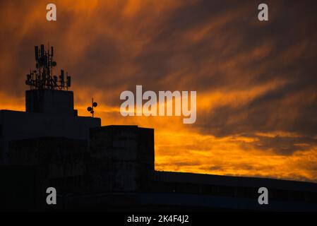 Gebäude Silhouette und TV-Antennen gegen orange farbigen dramatischen Sonnenuntergang. Schöner Spätnachmittag. Salvador, Bahia, Brasilien. Stockfoto