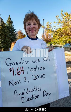 Warren, Michigan, USA. 1. Oktober 2022. Donald Trump unterstützt vor einer Kundgebung, bei der der ehemalige Präsident für die Kandidaten warb, die er bei den Parlamentswahlen in Michigan 2022 unterstützt hat. Eine Unterstützerin, die ihren Namen nur als „Jean“ nennen würde, trägt ein Zeichen über die Benzinpreise. Kredit: Jim West/Alamy Live Nachrichten Stockfoto