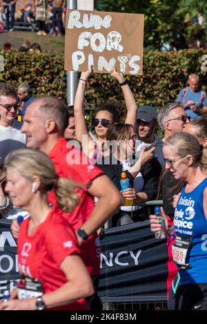 Tower Hill, London, Großbritannien. 2. Oktober 2022. Rund 50.000 Teilnehmer nehmen am TCS London Marathon 2022 Teil, darunter die besten Elite-Läufer der Welt. Die Masse der Club & Fun Läufer folgen mit vielen, die große Summen für wohltätige Zwecke sammeln. Unterstützer mit Schild, rauf nach Pints Stockfoto