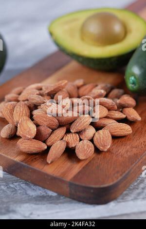 Nahaufnahme der Scheibe Avocado und Mandelnuss auf dem Schneidebrett. Stockfoto