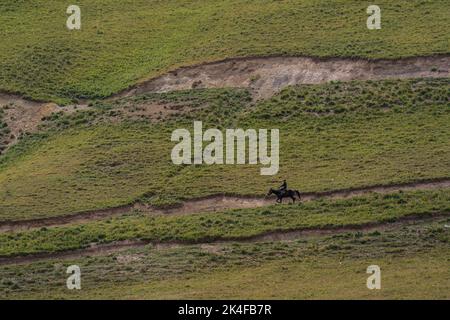 Einsiedliger Nomadenhirte auf Pferd in der Nähe des Song Kul Sees Stockfoto