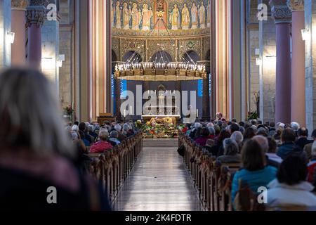 Hildesheim, Deutschland. 02. Oktober 2022. Beim Niedersächsischen Landeserntefest sitzen Menschen in der Pfarrkirche St. Godehard. Zum ersten Mal findet das staatliche Erntefest als ökumenisches Ereignis statt. Quelle: Moritz Frankenberg/dpa/Alamy Live News Stockfoto