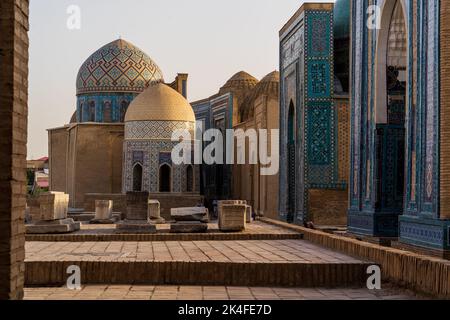 Blau geflieste Fassaden und goldene Kuppeln des Shah-i-Zinda-Mausoleums-Komplexes bei Sonnenuntergang, Samarkand Stockfoto