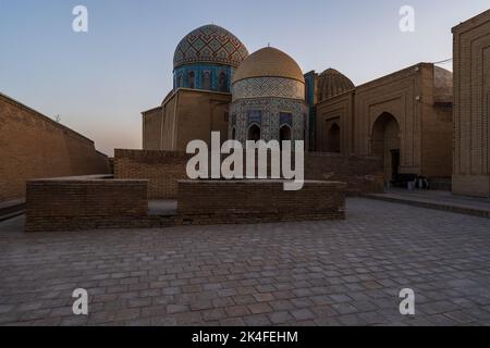 Die blau gefliesten Fassaden Kuppeln und Bögen des Shah-i-Zinda-Mausoleums-Komplexes bei Sonnenuntergang, Samarkand mit sehr wenigen oder gar keinen Menschen. Stockfoto