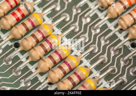 Reihe von Kohleschichtwiderständen und gelöteten Kabelkontakten auf der Leiterplatte eines 1982 16k Sinclair ZX Spectrum. Für elektronische Bauteile. Stockfoto