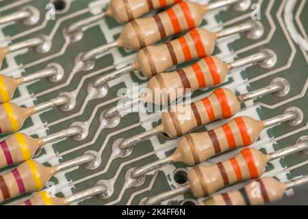 Reihe von Kohleschichtwiderständen und gelöteten Kabelkontakten auf der Leiterplatte eines 1982 16k Sinclair ZX Spectrum. Für elektronische Bauteile. Stockfoto