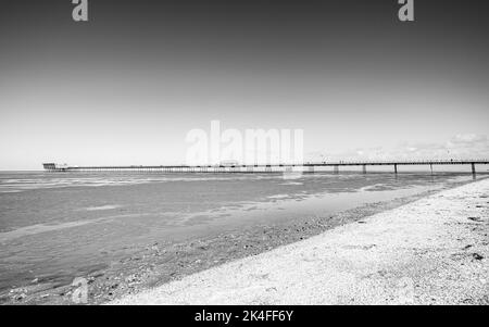 Ein Schwarz-Weiß-Bild des Southport-Piers, der bei Ebbe im Oktober 2022 in die Irische See ragt. Stockfoto