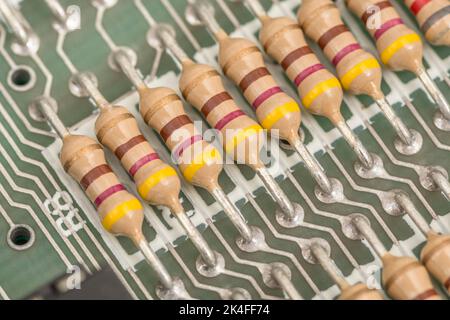 Reihe von Kohleschichtwiderständen und gelöteten Kabelkontakten auf der Leiterplatte eines 1982 16k Sinclair ZX Spectrum. Für elektronische Bauteile. Stockfoto