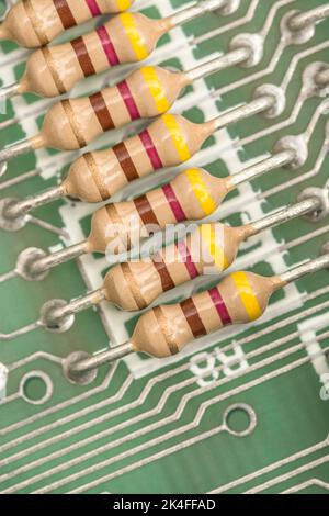 Reihe von Kohleschichtwiderständen und gelöteten Kabelkontakten auf der Leiterplatte eines 1982 16k Sinclair ZX Spectrum. Für elektronische Bauteile. Stockfoto