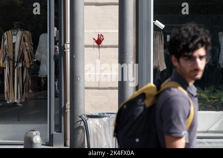 Ein Mann geht an einem blutigen Handprint an einer Wand vorbei. Am 2. Oktober 2022 fand in Toulouse (Frankreich) eine Kundgebung zur Unterstützung iranischer Frauen statt. Im Iran schwächt sich die Volksbewegung "Frau, Leben, Freiheit", die sich seit mehreren Tagen gegen das Mullahs-Regime erhebt, nicht ab. Der Tod der jungen Mahsa Amini, der während ihrer Festnahme geschah, weil sie einen Schleier trug, der nicht dem islamischen Gesetz entspricht, löste Proteste im Land aus, die stark unterdrückt wurden. Foto von Patrick Batard / ABACAPRESS.COM Stockfoto