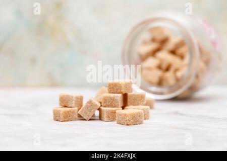 Braune Zuckerwürfel auf hellem Hintergrund Stockfoto