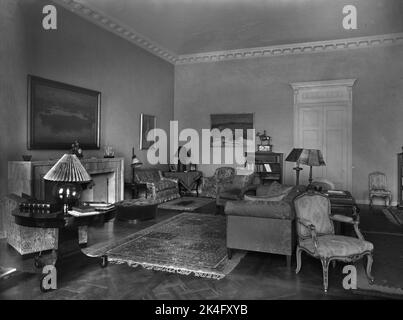 Interieur vom Schloss Haga in der Gemeinde Solna bei Stockholm. Das Wohnzimmer ist mit gepolsterten Sitzmöbeln vor dem Kamin ausgestattet. Nordisch Stockfoto