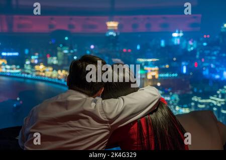 Ein Paar bewunderte den Blick auf den Bund von der Vue Bar im Hyatt on the Bund Hotel in Shanghai Stockfoto