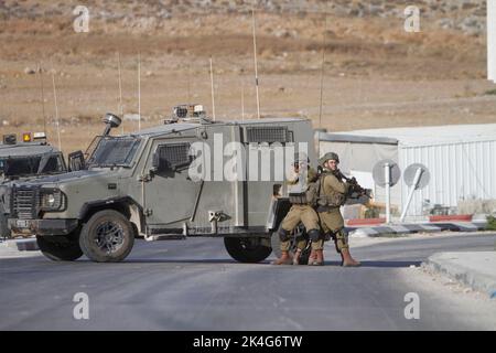 Nablus, Palästina. 02. Oktober 2022. Israelische Soldaten treffen auf bewaffnete Männer, die auf sie schossen, während sie während einer Militäroperation die Einfahrt zum Dorf Salem blockierten, um die Menschen zu suchen, die auf einem israelischen Bus das Feuer öffneten, während er eine Straße innerhalb der Siedlung Itamar überquerte, In der Nähe des Kontrollpunkts Beit Furik, der unter israelischer Kontrolle steht, östlich von Nablus im besetzten Westjordanland. Kredit: SOPA Images Limited/Alamy Live Nachrichten Stockfoto