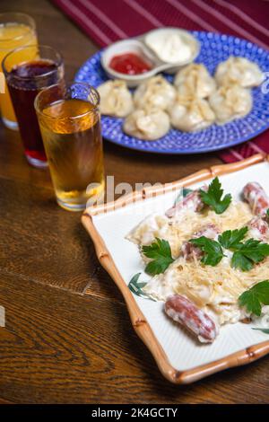 manti und Pasta auf dem Tisch, Saft in Gläsern Stockfoto