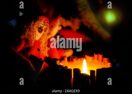 Zwei niedliche Stoffpuppen sitzen nachts am Feuer. Weihnachtskonzept Stockfoto