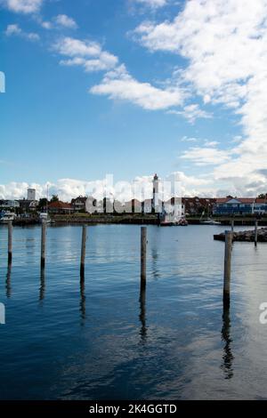 Hafen mit Booten und Blick auf Timmendorf Strand, mit Leuchtturm auf der Insel Poel, Mecklenburg-Vorpommern, Deutschland Stockfoto