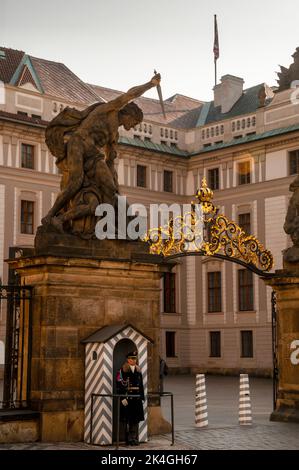 Barockstatue des Kolosses, goldenes filagree-Bogentor und Burgwache am Eingang zum Prager Burgkomplex, Tschechische Republik. Stockfoto