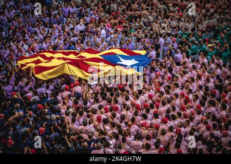 Tarragona, Spanien. 2. Oktober 2022. Zu Beginn des dritten Tages des Tarragona Human Tower Competition 28. in Tarragona wird eine "Estelada"-Fahne über die versammelten Castellers überfahren. Der Wettbewerb findet alle zwei Jahre statt und zeigt die wichtigsten 'Castellers'-Teams (Colles) Kataloniens während einer dreitägigen Veranstaltung, die vom Rathaus von Tarragona organisiert wird.Quelle: Matthias Oesterle/Alamy Live News Stockfoto