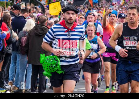 London, 2.. Oktober 2022. Mehr als 40.000 Teilnehmer gehen zum London Marathon 42. auf die Straßen der Hauptstadt. Die Veranstaltung, die Eliteläufer und Rollstuhlfahrer anzieht, bringt auch Millionen Pfund für wohltätige Zwecke durch die Teilnahme von Club- und Fitnessläufern zusammen mit denen, die nur die 26 Meilen Herausforderung annehmen wollen. Läufer in traditioneller französischer Kleidung aus Baskenmütze und gestreiftem Hemd. Stockfoto