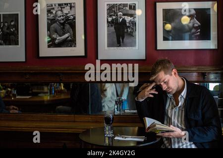 Der Mann liest ein Buch im Pub, French House Pub in Soho, Soho, London, England, Großbritannien Stockfoto