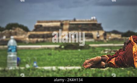 Die Füße eines Arbeiters, der in Hampi auf dem Gras liegt Stockfoto