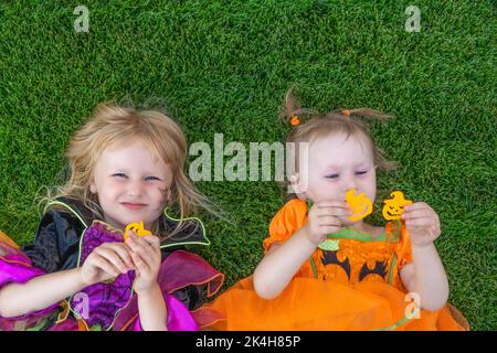 Lustige kleine Kinder an halloween in einem Hexenkostüm und Kürbis im Freien gekleidet. Halloween, Urlaub und Kindheit Konzept. Stockfoto