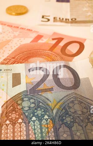 Nahaufnahme von 5, 10, 20 Euro-Banknoten und Münzen auf weißem Hintergrund. Stockfoto