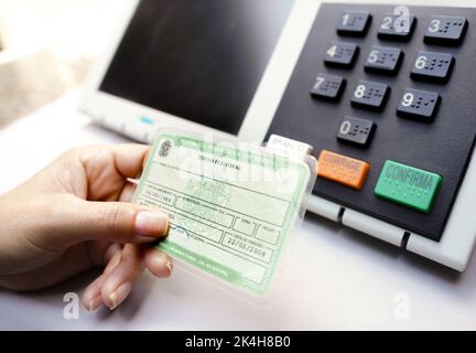 In dieser Fototafel besitzt der Wähler den Wahltitel (Wählerlizenz) - Pflichtposten bei brasilianischen Wahlen mit einer elektronischen Urnenwahlliste im Hintergrund. Stockfoto