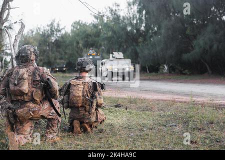 Soldaten der US-Armee werden Alpha Company, 2. Bataillon, 27. Infanterie-Regiment, 3. Infanterie-Brigade-Kampfteam, 25. Infanterie-Division aus Schofield Barracks, Hawaii, zugewiesen, bereiten sich auf die Verbindung mit 1. Bataillon, 94. Field Artillery Regiment Hight Mobility Artillery Rocket System Vehicles auf der Andersen Air Force Base, Guam, 26. September vor 2022. Die Trainingsübung zwischen den beiden Einheiten zeigt die Fähigkeit von Alpha Company, einen Raum für die HIMARS zu räumen und zu sichern, um ihre Feuermissionen durchzuführen. Stockfoto