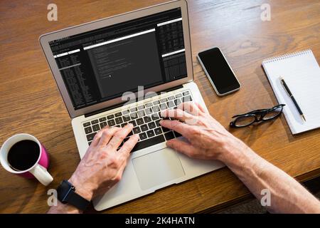 Geschäftsmann, der im Büro einen Laptop benutzt Stockfoto