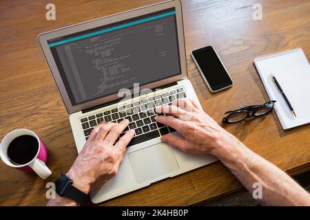 Geschäftsmann, der im Büro einen Laptop benutzt Stockfoto