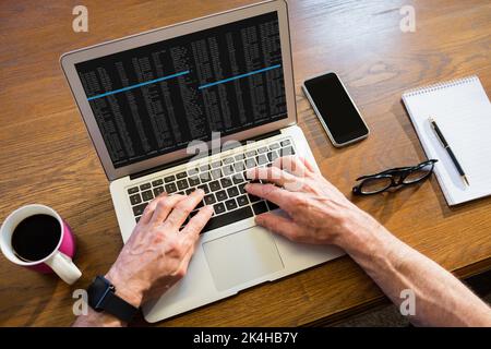 Geschäftsmann, der im Büro einen Laptop benutzt Stockfoto