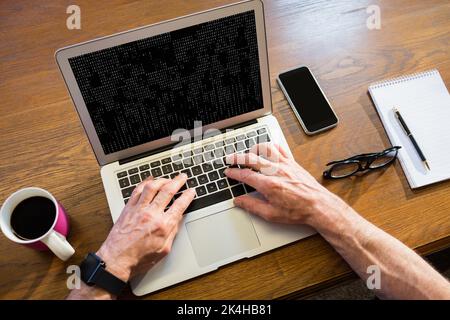 Geschäftsmann, der im Büro einen Laptop benutzt Stockfoto