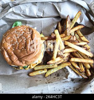 Ein Sandwich mit fünf Jungs, das auf einem Stapel Pommes frites sitzt Stockfoto