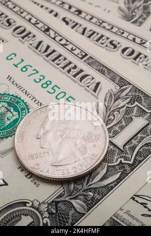 25-Cent-Münze IN DEN USA auf einem Dollar-Schein. Stockfoto
