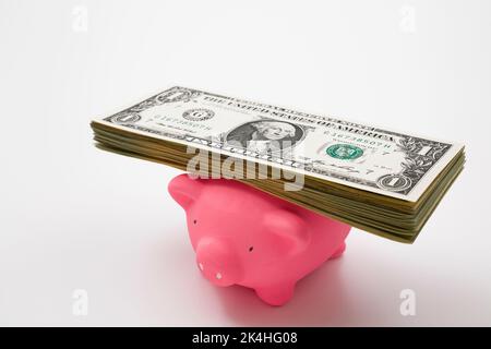 BANKNOTEN DER US-Währung auf dem rosa Sparschwein. Stockfoto