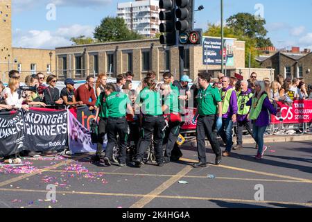 London, Großbritannien. 02. Oktober 2022. Das medizinische Team wurde mit einem der Läufer in Aktion gesehen, der während des Londoner Marathons bei der Meile 21 Hilfe benötigte. Zum ersten Mal wurde eine Strecke der London Marathon-Route in Rainbow Row umgewandelt, um die LGBTQIA-Community zu feiern, die Inklusivität zu fördern und eine Partyatmosphäre zu schaffen, die auf der Meile 21 aufgeht. Marathonläufer passieren zwei Etappen mit Musik- und Drag-Darbietungen und die Straße, die in der Regel Butcher Row in Limehouse heißt, ist mit bunten Flaggen und Adern bedeckt. Kredit: SOPA Images Limited/Alamy Live Nachrichten Stockfoto
