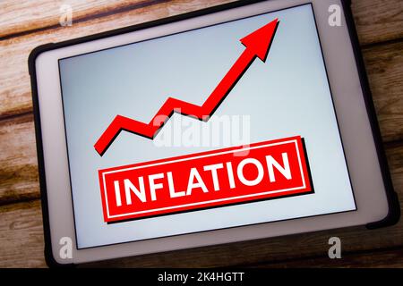 Stichwort Inflation auf Tablet auf schäbig schickem Holztisch. Erhöhung der Preise für Waren oder Dienstleistungen und Wirtschaftskrise Konzept. Stockfoto